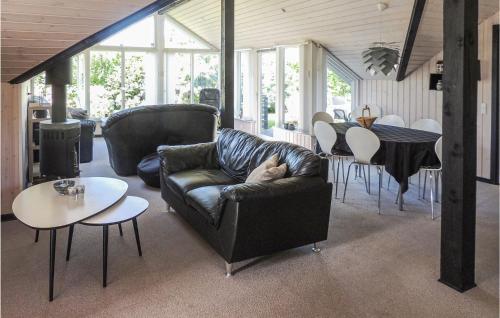 a cat sleeping on a leather couch in a living room at Gorgeous Home In Hemmet With Wifi in Hemmet
