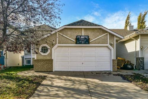 a house with a white garage in front of it at Airport 4BR2BA Mainfloor Suite 1min walk to bus stop in Calgary