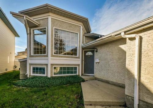 a brick house with a blue door at Airport 4BR2BA Mainfloor Suite 1min walk to bus stop in Calgary