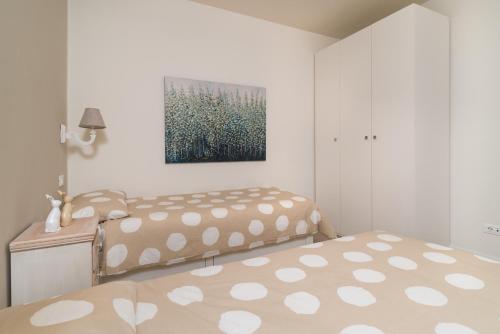 a bedroom with two beds and a painting on the wall at Casa Angelina in Crone