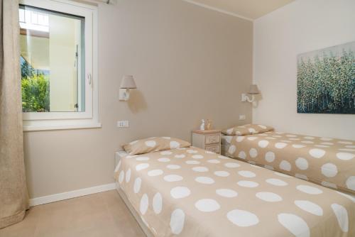 two beds in a white room with a window at Casa Angelina in Crone