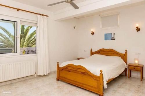 een slaapkamer met een houten bed en een raam bij Casa Delfin - Moraira in Moraira