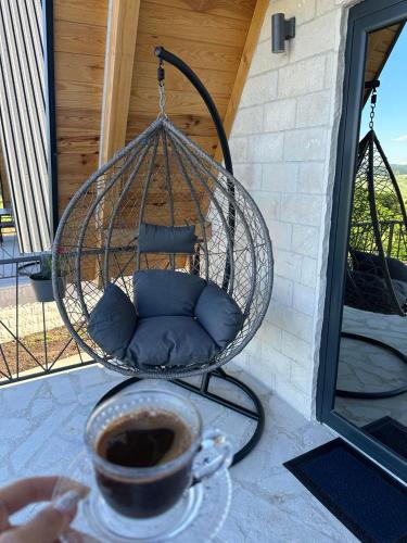 a swing on a porch with a cup of coffee at Monte zone in Žabljak