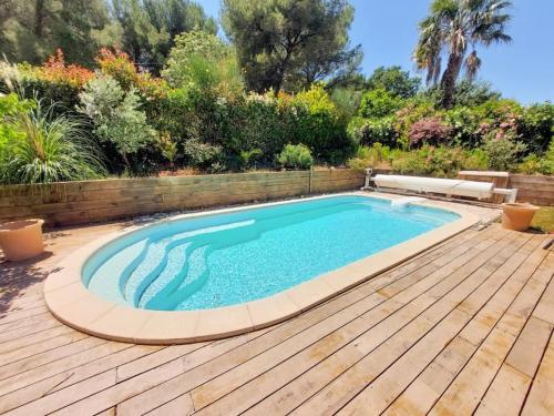une piscine sur une terrasse en bois à côté d'un plancher en bois dans l'établissement Villa au pradet avec piscine les pieds dans l'eau, au Pradet
