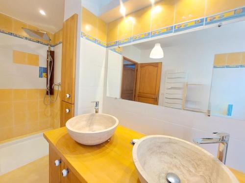 une salle de bain avec un lavabo et un grand miroir dans l'établissement Villa au pradet avec piscine les pieds dans l'eau, au Pradet