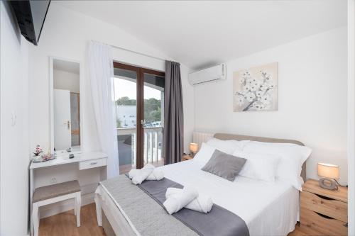 ein Schlafzimmer mit einem Bett mit Schreibtisch und einem Fenster in der Unterkunft Holiday Home DaLeo in Zadar