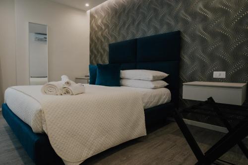 a bedroom with a large bed with towels on it at Marcone Luxury Rooms - Il giardino di pietra in Trani