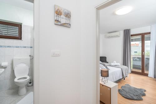 ein Bad mit einem WC und ein Schlafzimmer mit einem Bett in der Unterkunft Holiday Home DaLeo in Zadar