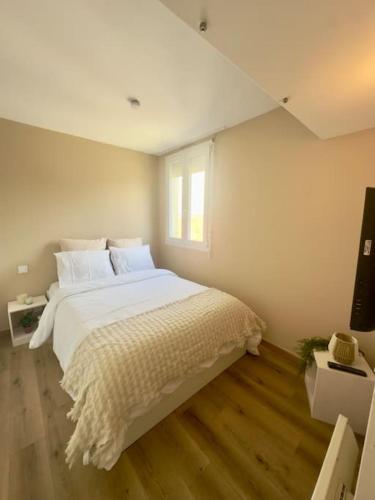 une chambre avec un grand lit blanc et une fenêtre dans l'établissement Appartement neuf et rénové promenade des anglais, à Nice