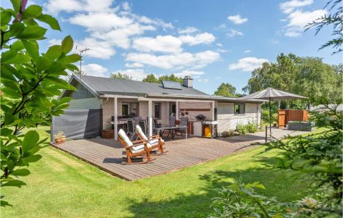 a backyard with a wooden deck and a house at Three-Bedroom Holiday Home In Vig in Vig
