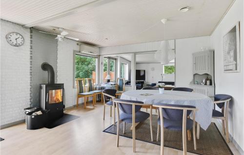 a kitchen and dining room with a table and a fireplace at Three-Bedroom Holiday Home In Vig in Vig