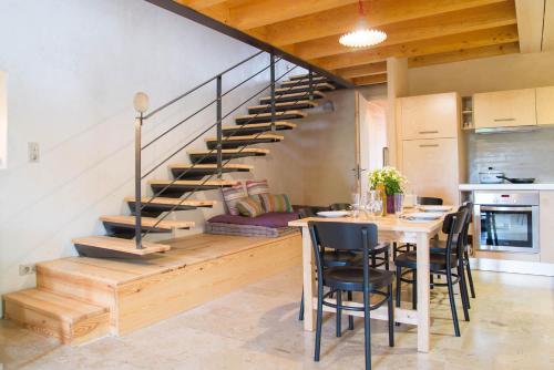 une salle à manger avec une table et un escalier en colimaçon dans l'établissement Domaine la vigne au villard jeune, à Chanac