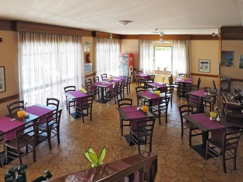 チヴィタノーヴァ・マルケにあるHotel Velusの紫色のテーブルと椅子が備わるダイニングルーム