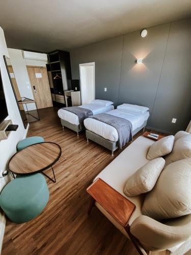 a room with two beds and a couch and tables at Midland Hotel & Resort All Inclusive in Paso de los Toros