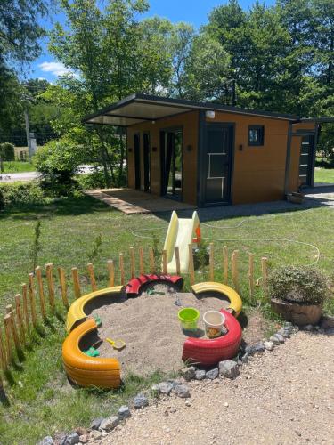 a playground in front of a house with a sandbox at Krupajsko vrelo in Milanovac