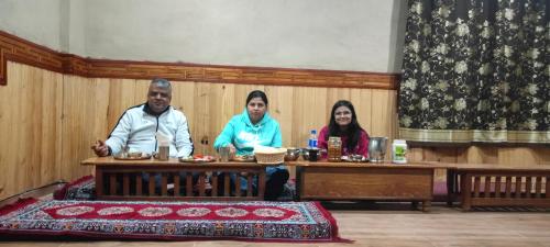 a group of three people sitting at a table at nako valley home stay in Nako