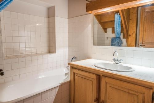 a bathroom with a sink and a bath tub at Gîte Gîtes de France 3 épis 5/6 personnes à Chirac in Chirac