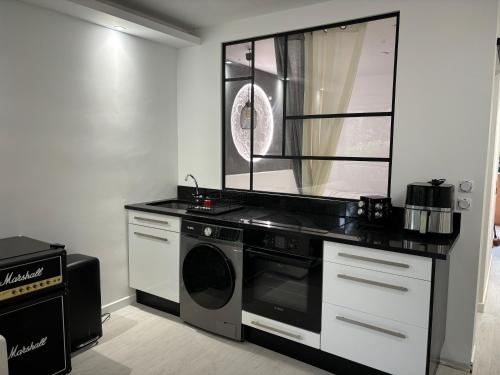 une cuisine avec une cuisinière et une machine à laver dans l'établissement Appartement Bord de Mer Saint Aygulf, à Fréjus