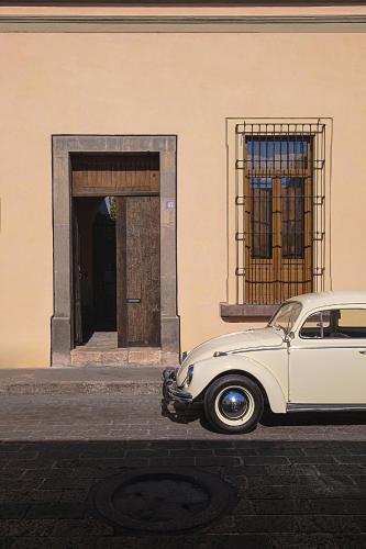 a white car parked in front of a building at Veinticinco20h in Querétaro