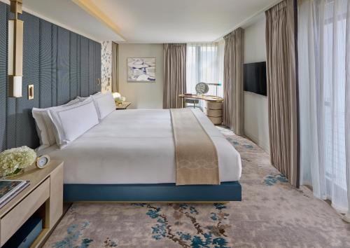 a hotel room with a large bed and a desk at Mandarin Oriental Mayfair, London in London
