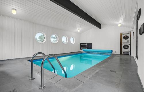 a swimming pool in a white room with a blue pool at Nice Home In Glesborg With Kitchen in Bønnerup Strand