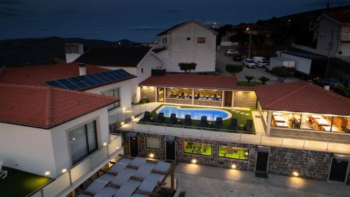 an aerial view of a house with a swimming pool at night at Socalcos do Douro House in Valença do Douro