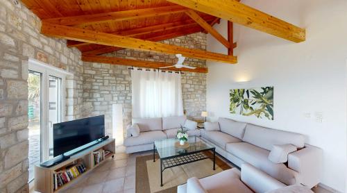 a living room with a couch and a tv at Villa Noema in Gaios