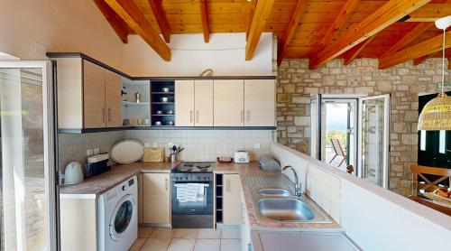 a kitchen with a washer and dryer in it at Villa Noema in Gaios