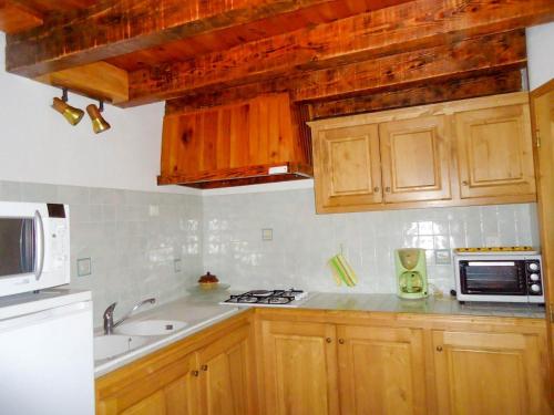 La cuisine est équipée de placards en bois, d'un évier et d'un four micro-ondes. dans l'établissement Gites de france 2 pers aux laubies, à Saint-Étienne-du-Valdonnez
