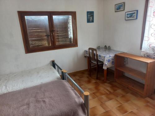 - une chambre avec une table, un lit et un bureau dans l'établissement CHAMBRE lumineuse jardin arboré, à Montpellier