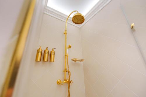 a shower with gold fixtures in a bathroom at Boutique Hotel Teatro in Angra do Heroísmo