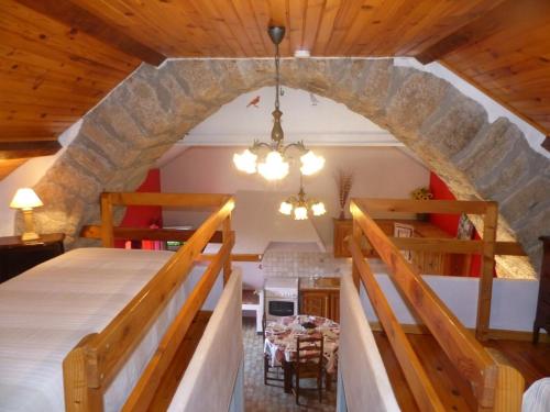 une chambre avec un grand lit et un mur en pierre dans l'établissement Gîte Gîtes de France 4/6 personnes aux Laubies, à Saint-Étienne-du-Valdonnez