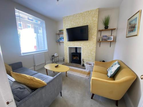a living room with a couch and a fireplace at Sea Biscuit Cottage, Scarborough in Scarborough