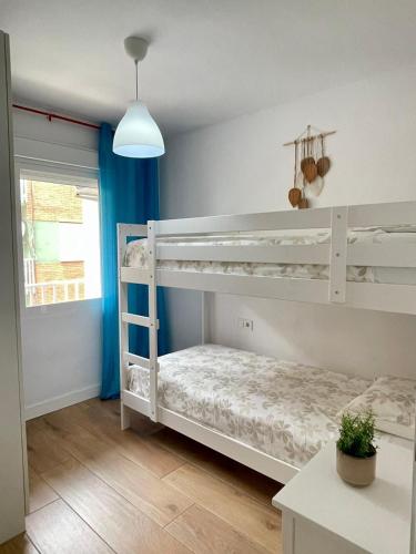 a bedroom with white bunk beds in a room at UIM Mediterraneo Conqueridor Wifi in Sagunto