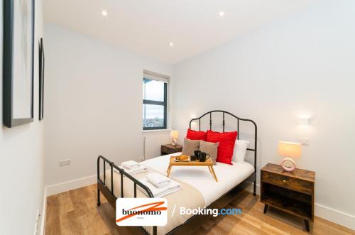 a bedroom with a bed with red pillows and a table at Two Bedroom Apartment At Buonomo Stays Short Lets & Serviced Accommodation close to Wimbledon Tennis Courts in London
