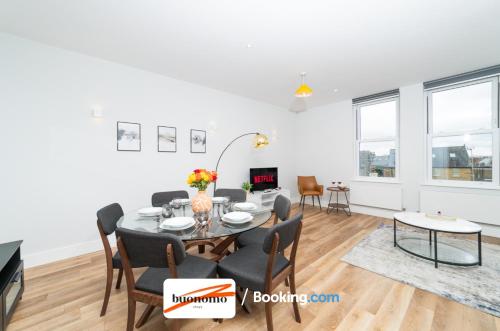a dining room and living room with a table and chairs at Two Bedroom Apartment At Buonomo Stays Short Lets & Serviced Accommodation close to Wimbledon Tennis Courts in London