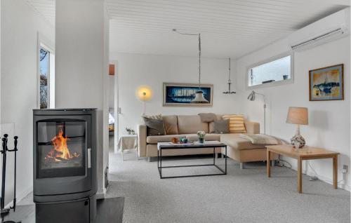 a living room with a fireplace and a couch at Holiday Home Farsø Qr-1965 in Hvalpsund