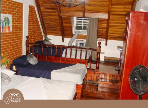a bedroom with two beds in a room with wooden floors at Private rooms, 10 min from SJO Airport in Ciudad Cariari