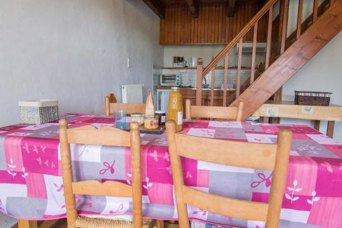 - une table à manger avec une nappe rose dans l'établissement Gîte Location 3/4 pers à Grandviala, à La Chaze-de-Peyre