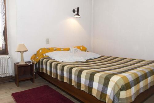 une chambre avec un lit avec une couverture jaune et blanche dans l'établissement Gîte Location 3/4 pers à Grandviala, à La Chaze-de-Peyre
