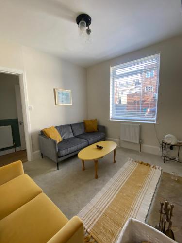 a living room with a couch and a table at Sea Biscuit Cottage, Scarborough in Scarborough