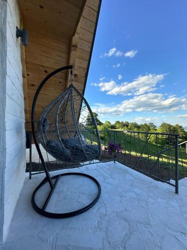 a swing on a porch with a fence at Monte zone in Žabljak