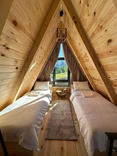 two beds in a attic room with a window at Monte zone in Žabljak