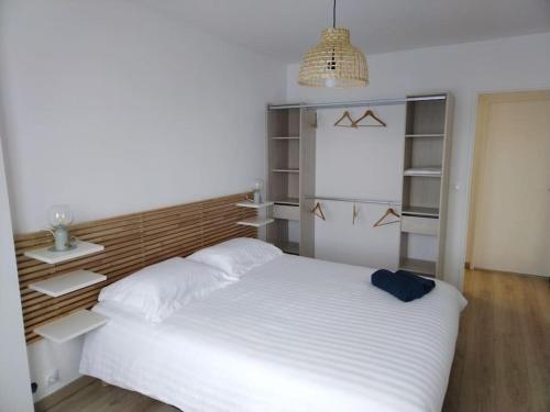 - une chambre avec un grand lit blanc et des étagères dans l'établissement L'Entre-Nous, à Pontault-Combault
