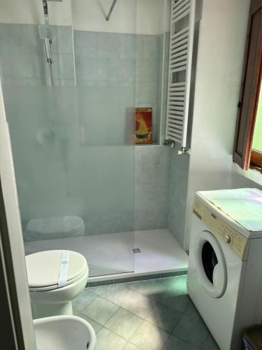 a bathroom with a shower with a toilet and a washing machine at Lovelyloft Navigli - Gelsomino in Milan