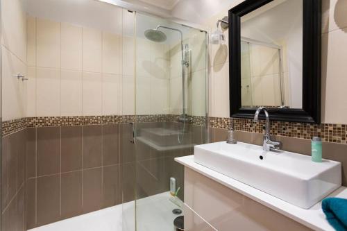 une salle de bain avec un lavabo, une douche et un miroir dans l'établissement Appartemment terrasse parking centre historique, à Bordeaux