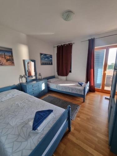 a bedroom with two beds and a window at Stone House Iva in Kraljevica