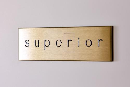 a wooden sign with the word superior on a wall at SARPI Apartment & Suite in Udine