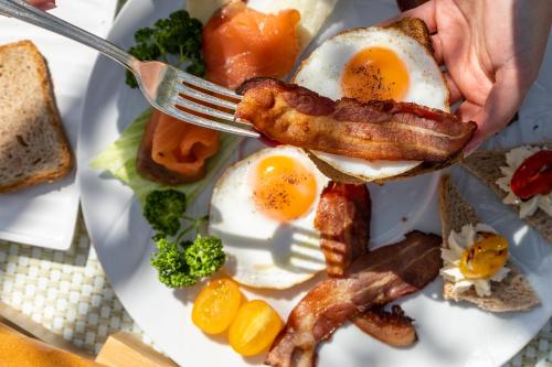 a plate of breakfast food with eggs bacon and toast at Hotel Aquila D'Oro Desenzano in Desenzano del Garda