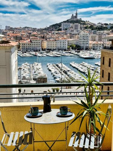 une table sur un balcon avec vue sur un port dans l'établissement Vue Incroyable & Confort au Vieux Port 4 personnes, à Marseille